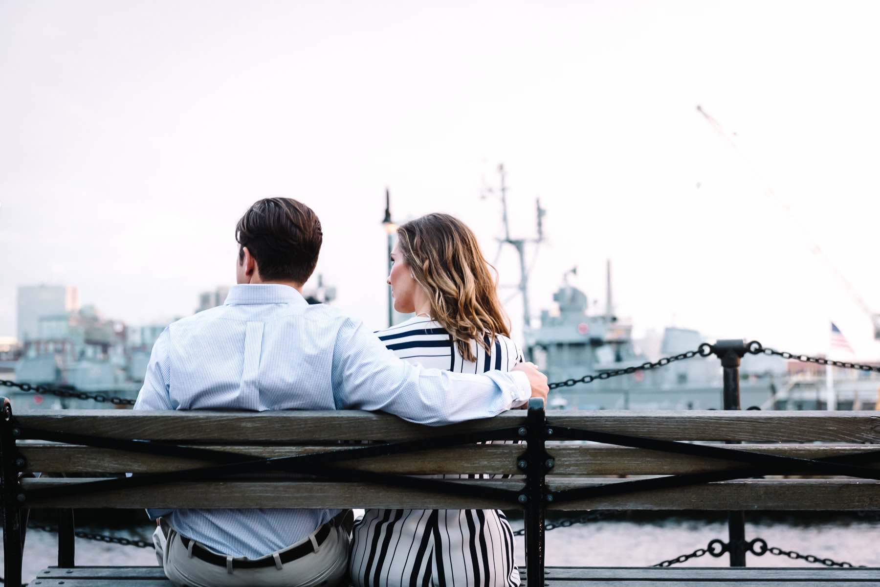 Business couple sitting on a bench next to boat docks