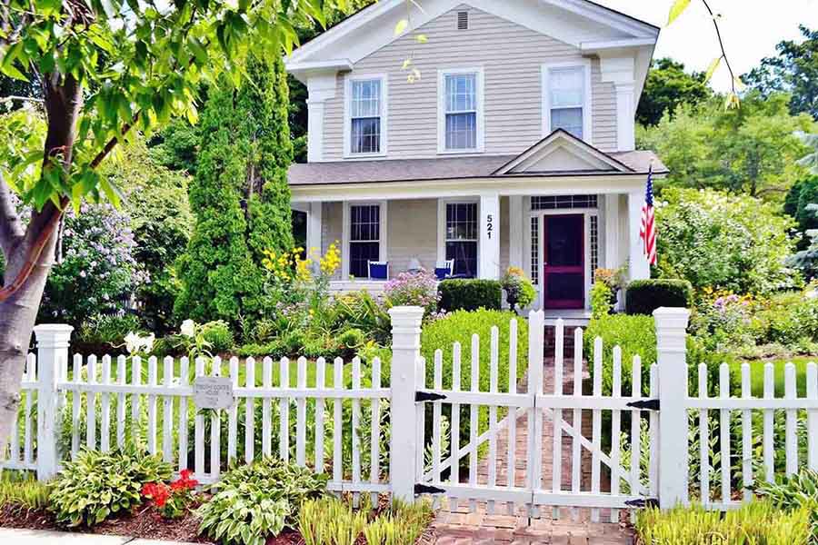 Exterior of a standalone home with a white fence
