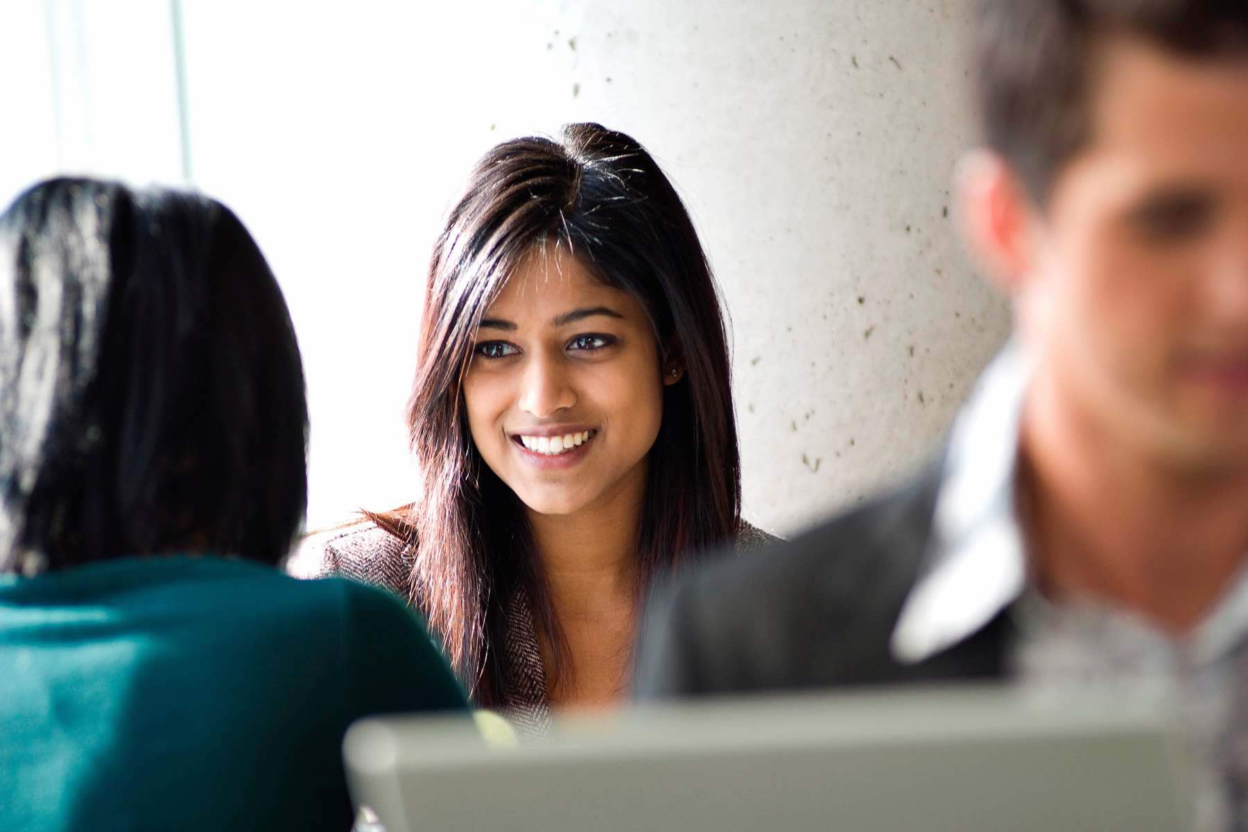Young ethnic businesswoman chatting to colleague.