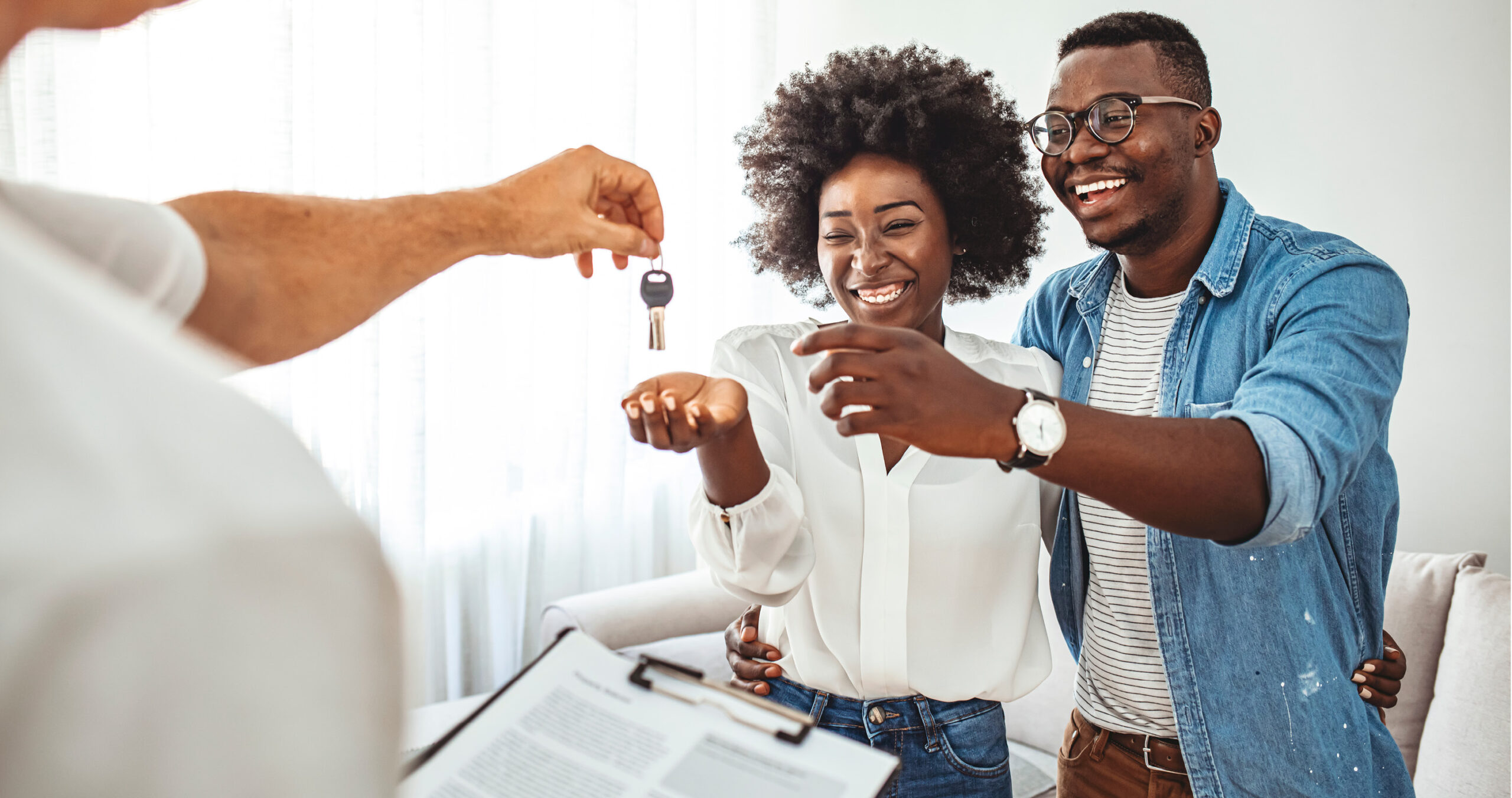 African American couple getting keys to their new home on closing day.