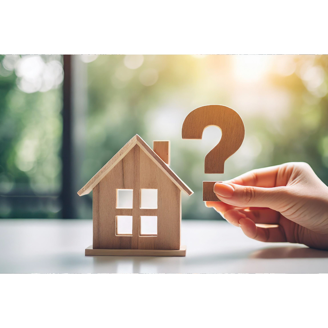 wooden house and hand holding question mark