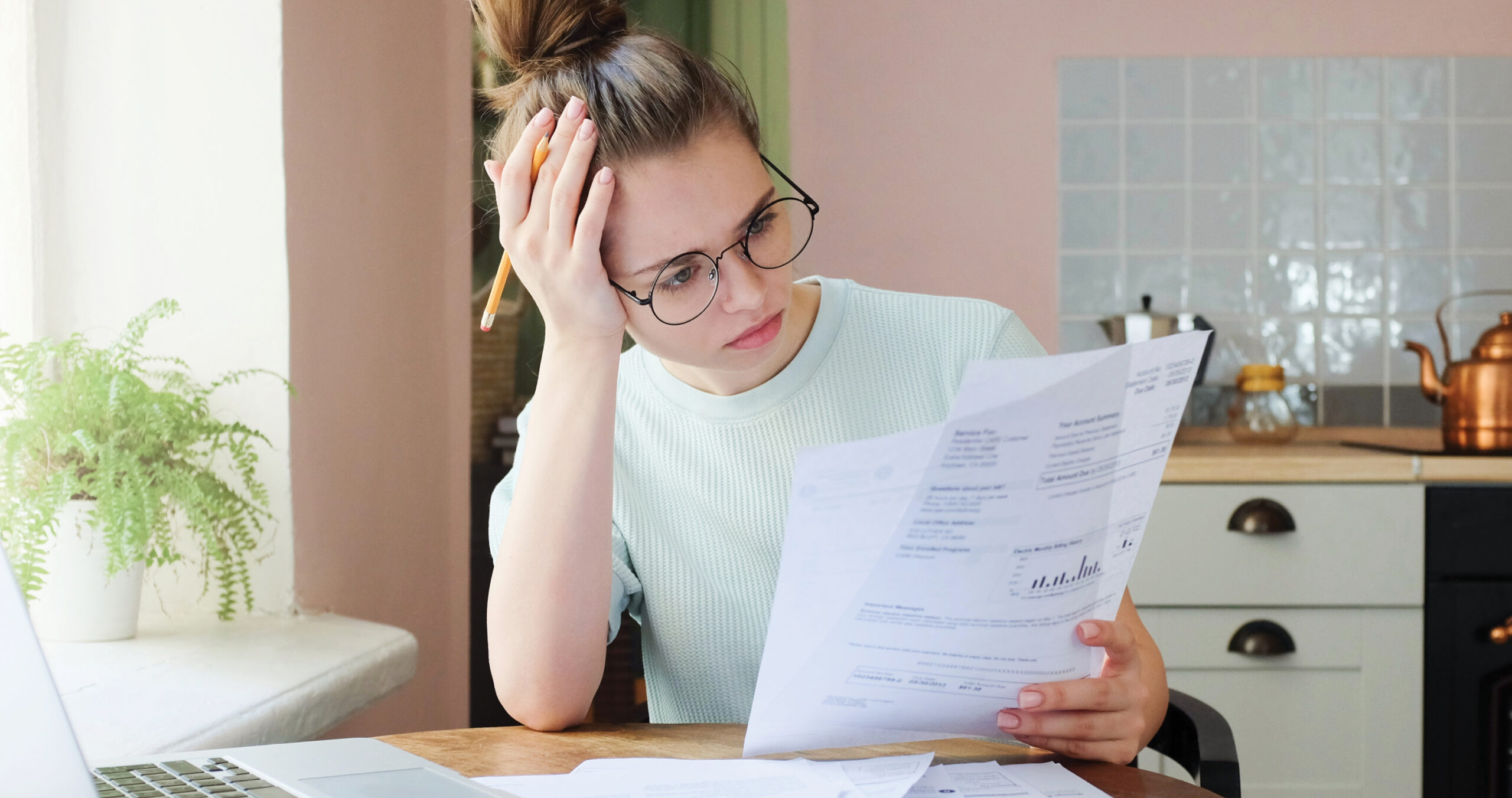 Concerned woman at table reviewing financial documents