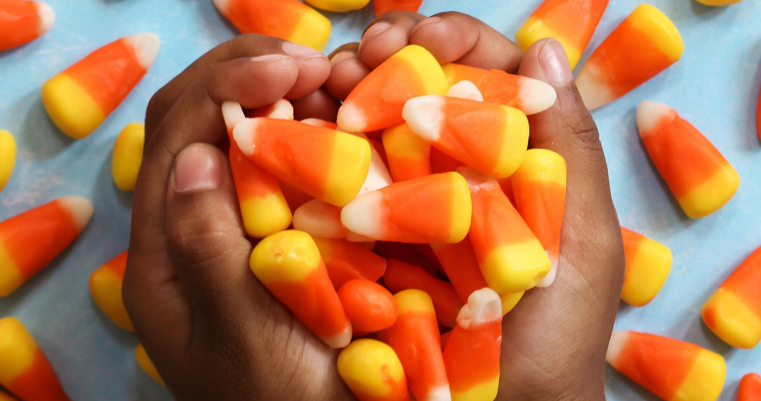 close up of child's hands holding candy corn